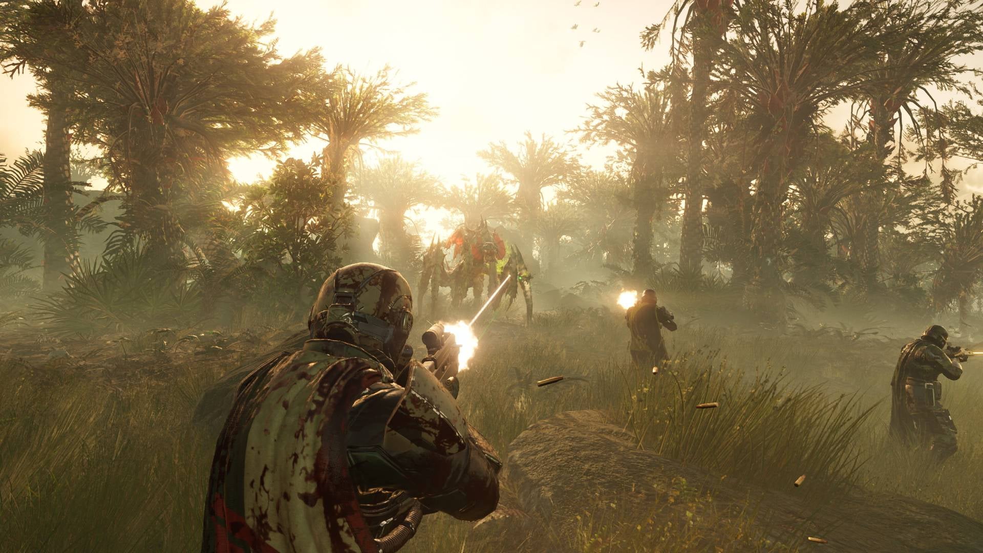 A Helldiver shooting at a big Terminid enemy in a jungle environment, with two more Helldivers in front also shooting. - 1