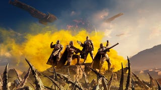 Helldivers 2 banner art showing a squad of four Helldivers standing triumphantly atop a hill, with yellow smoke behind them, ships in the sky above, and alien bugs below.