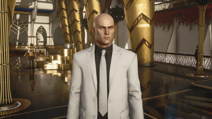 A screenshot of Agent 47 in a sharp looking suit from Hitman 3’s Dubai level