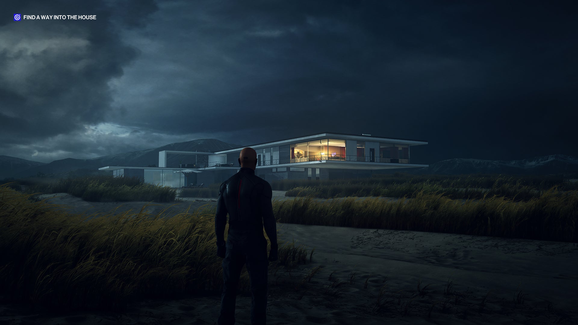 A screenshot of Ian Hitman standing on the beach at Hawke&rsquo;s Beach, looking towards the modern seaside home, at night.
