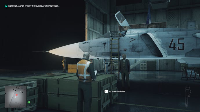 Ian Hitman is in disguise as a mechanic in the ICA training facility. He is in front of a jet, but the jet is fake and unpainted, and the walls of the hanger are made of plywood