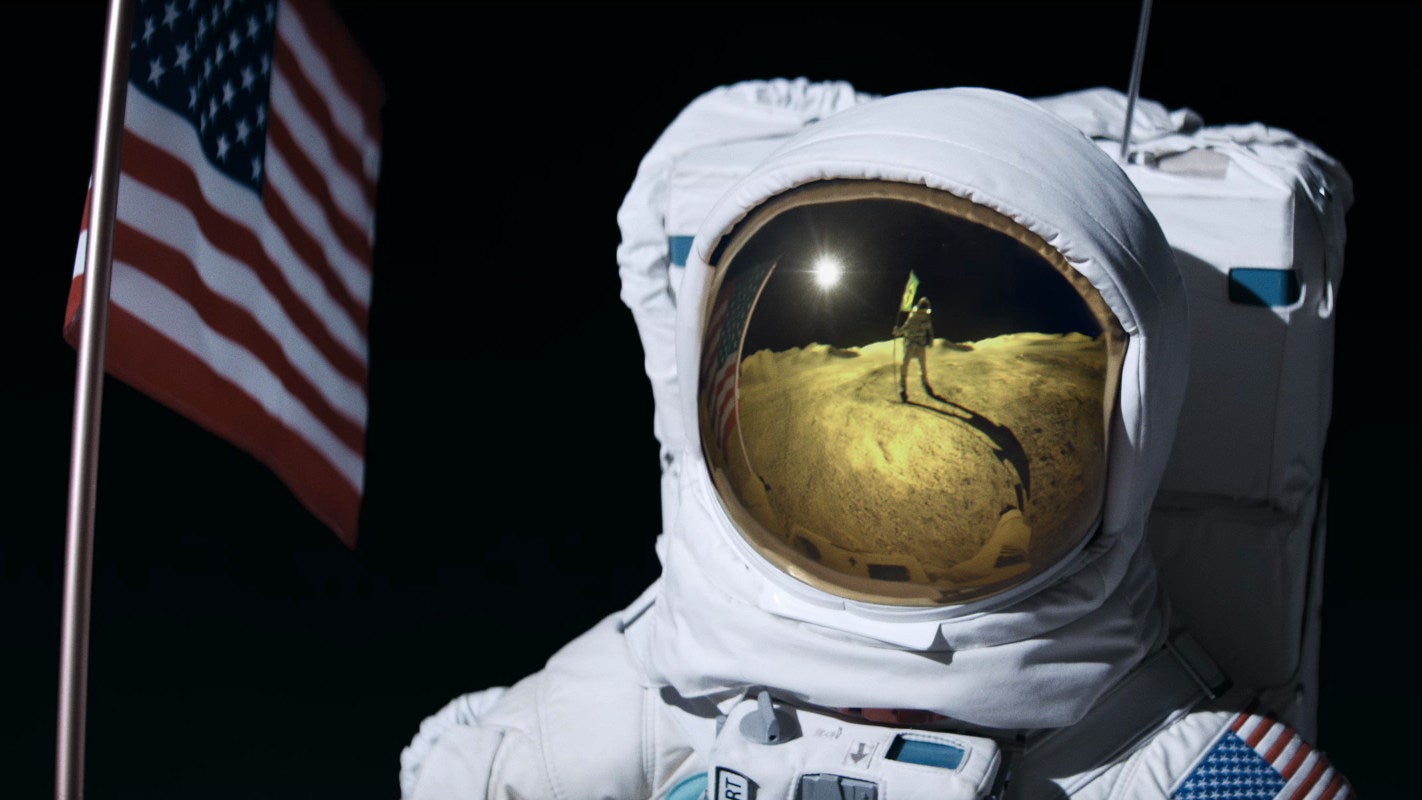 An astronaut on the Moon with a USA flag stares at another astronaut holding a Brazillian flag. - 1