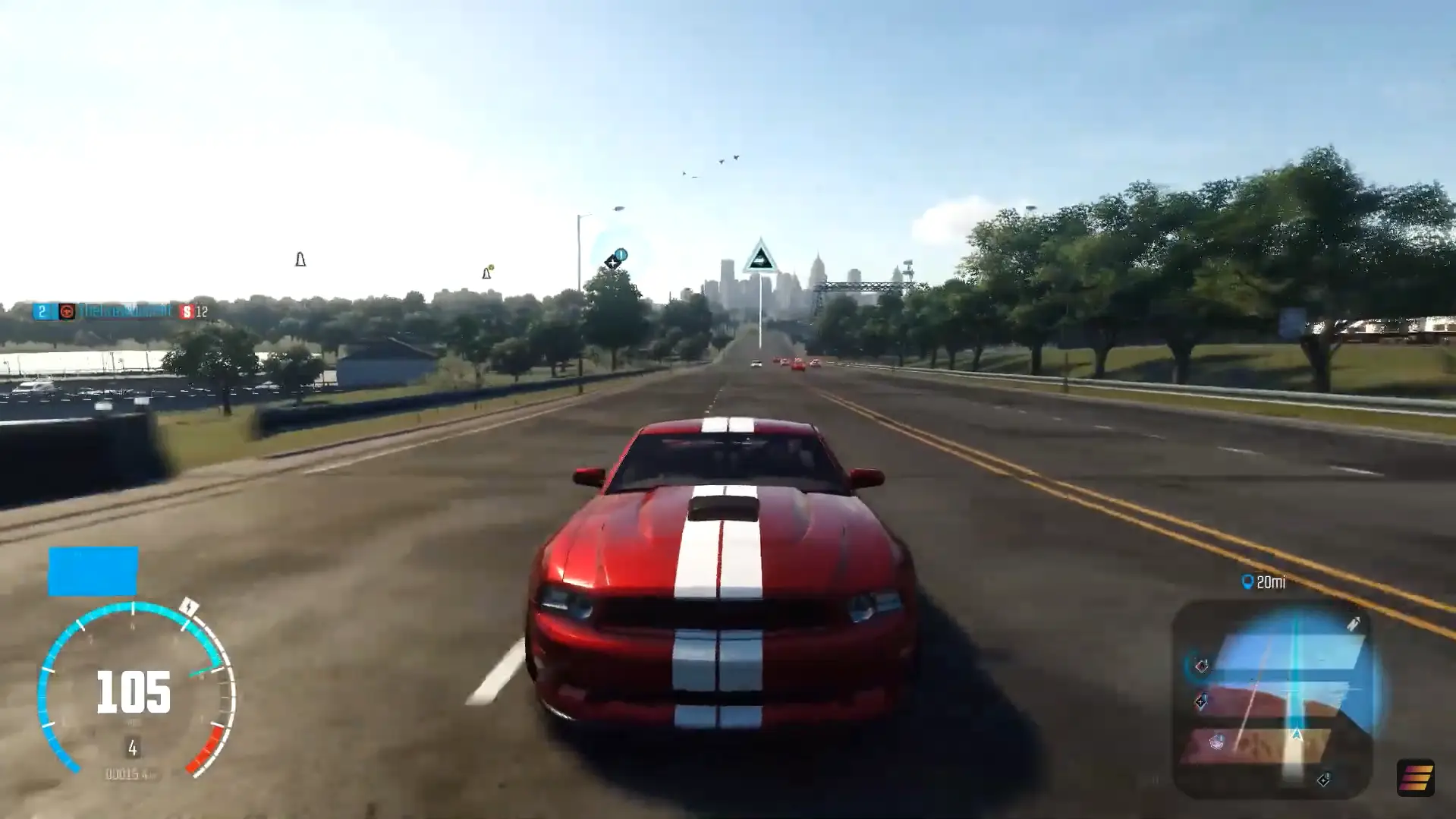 Image showing a red car with a white strip down the centre driving along a brightly lit road