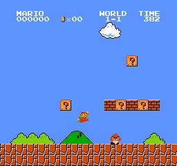 Mario jumps through the 2D world of Super Mario Bros. There are hills and a cloud in the sky behind him, and blocks overhead. A Goomba lies in front of him.