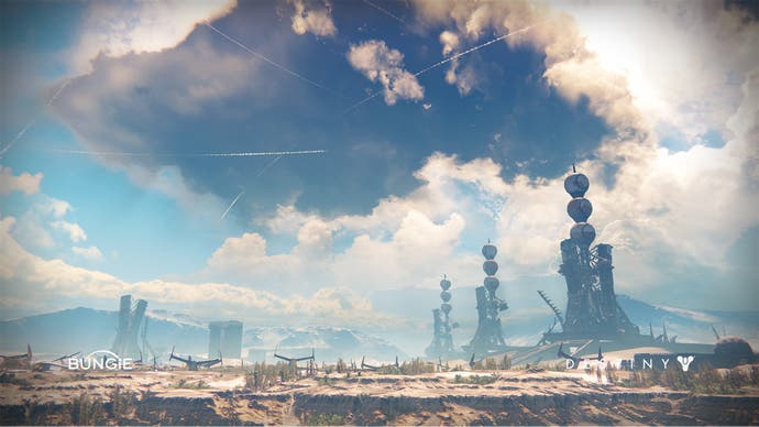 A collection of futuristic factory towers sit underneath an enormous stormcloud in this screen from Destiny.