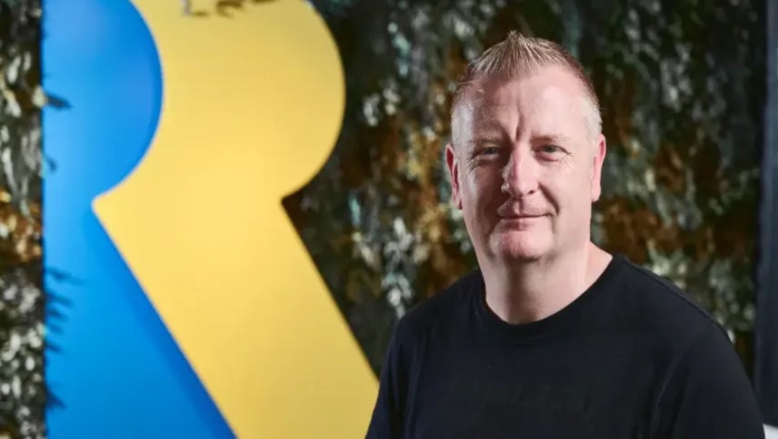Craig Duncan stands in front of Rare's logo
