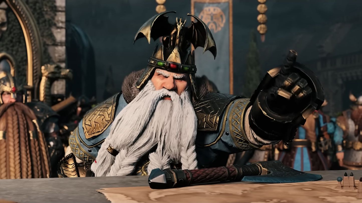 A still from the Total War Warhammer 3 Immortal Empires trailer, showing a white bearded dwarf looking very angry and pointing over a table at someone off screen - 1