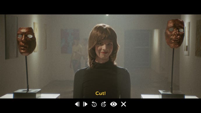 A woman stands in an art gallery between to male masks on plinths, in a clip from Immortality