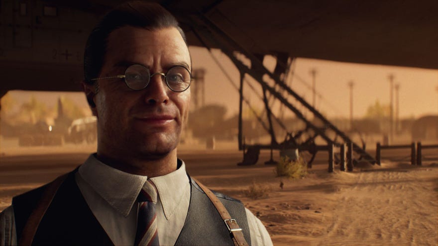 Emmerich Voss stands in the Egyptian desert with a zeppelin behind him.