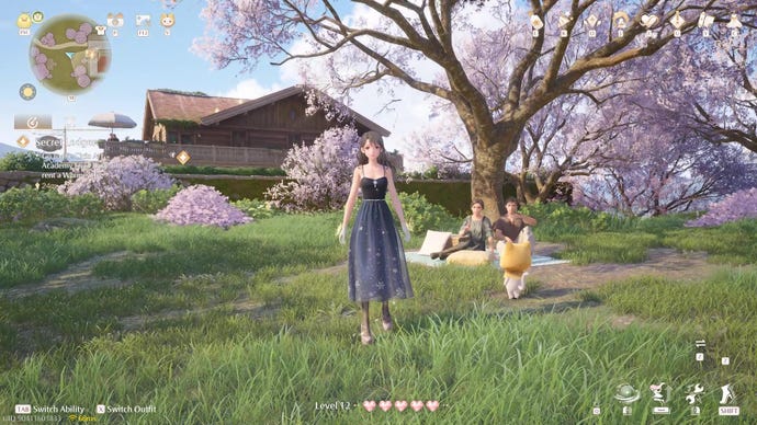Nikki wears a dress and stands next to a couple picnicking under a cherry blossom tree.