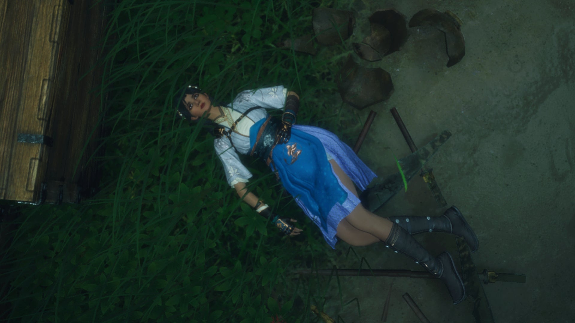 A female player character lies injured in the grass in Where Winds Meet. - 1