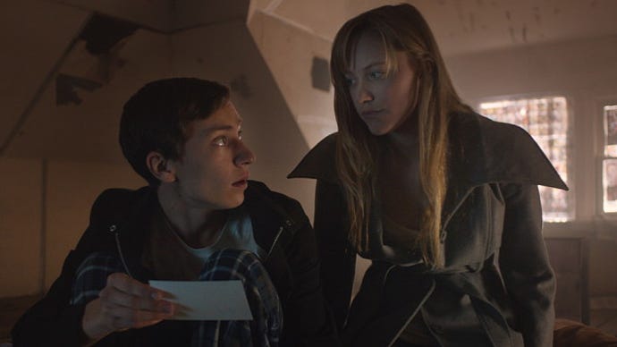 A still from It Follows showing a young man and woman looking at each other, the man holding up a photograph.