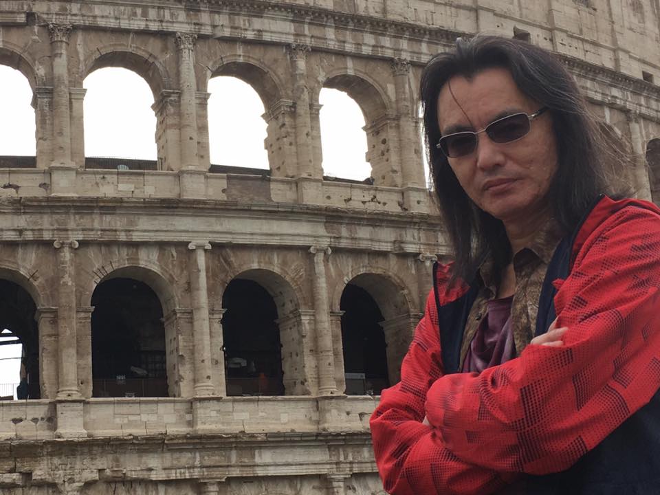 Tomonobu Itagaki standing in front of the Colosseum