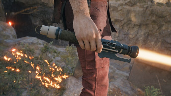 A close-up screenshot of an orange-bladed lightsaber in Cal’s hand in Jedi: Survivor.