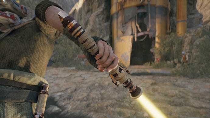 A close-up screenshot of a yellow-bladed lightsaber in Cal’s hand in Jedi: Survivor.