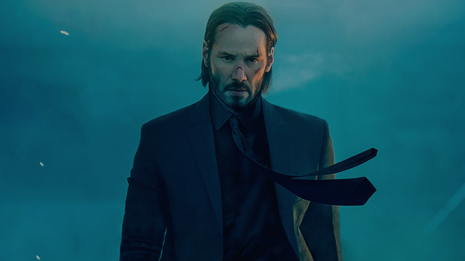 Keanue Reeves as John Wick, he&rsquo;s a bit beaten up, it&rsquo;s smokey around him, his tie being blown by the wind.
