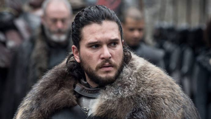 Game of Thrones' Jon Snow looking slightly concerned about something, with numerous people stood behind him.