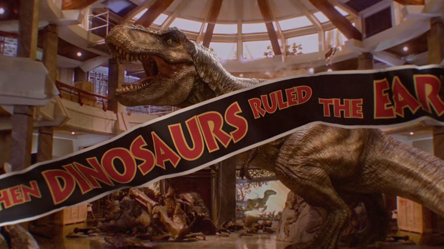 A screenshot from Jurassic World Evolution 2, recreating the scene from the original Jurassic Park movie where a t-rex stomps around the welcome centre, behind the ‘When Dinosaurs Ruled The Earth’ banner