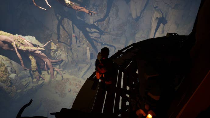 Looking down into a cavern from a great height in Jusant, seeing the remains of city buildings