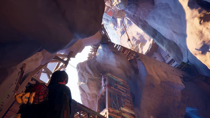 Looking up from the bottom of a cliff at a serious of ledges and wooden walkways in Jusant