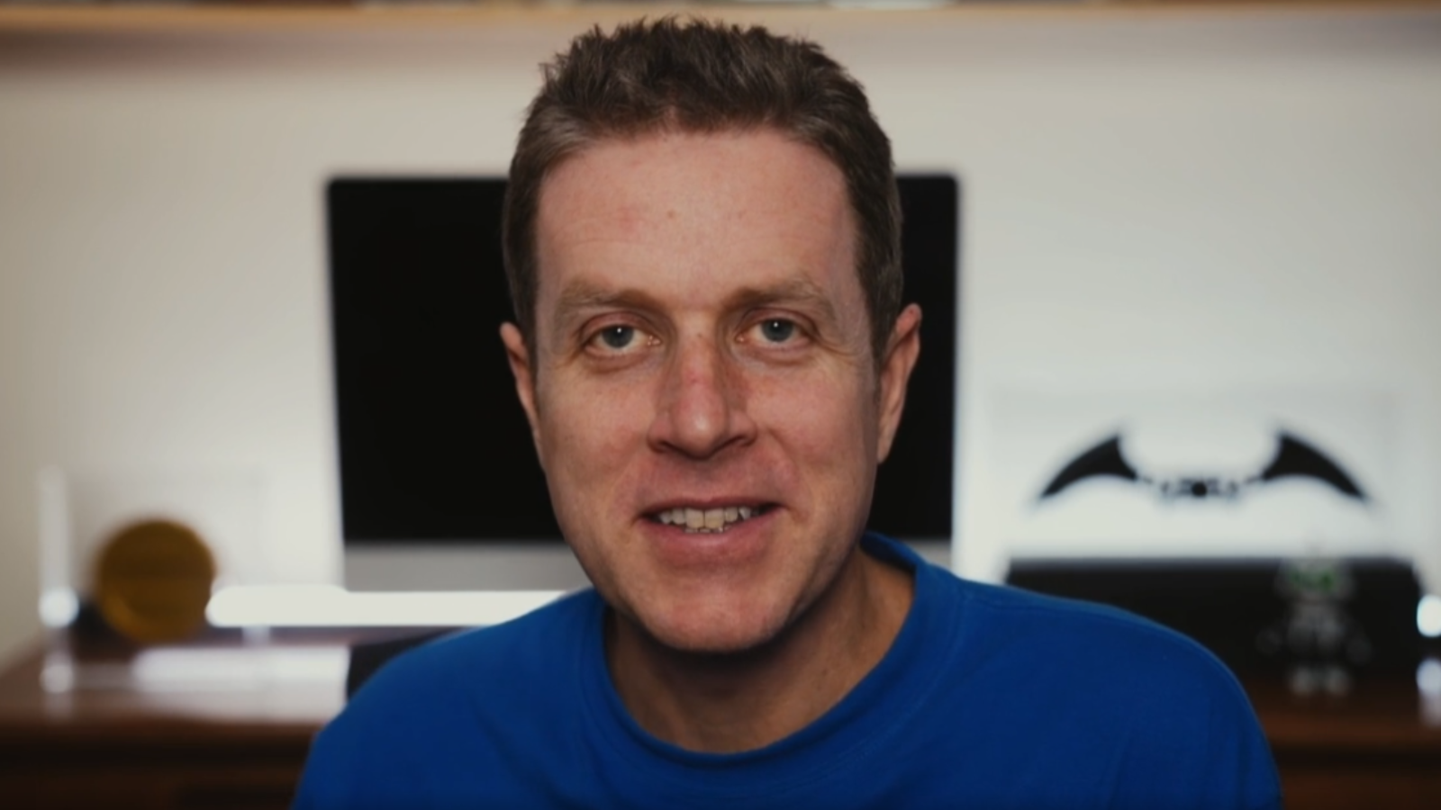 Close up screenshot of Keighley on a Twitch stream with a monitor behind him