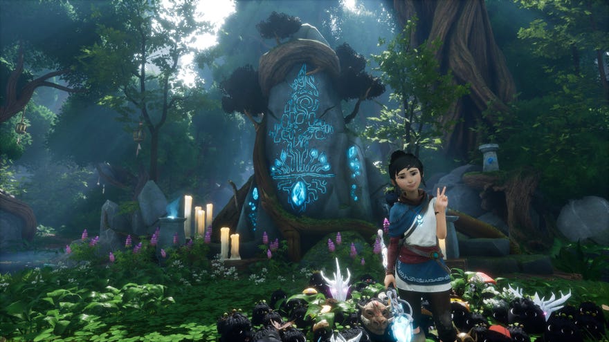 Kena posing in front of the Fishing Shrine in Kena: Bridge of Spirits.