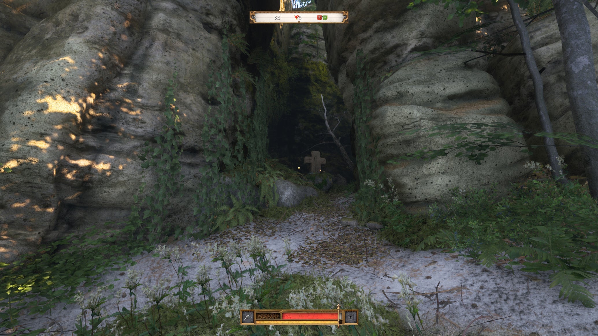 A stone cross and small altar tucked into an alcove beneath some large rocks in Kingdom Come Deliverance 2 - 1