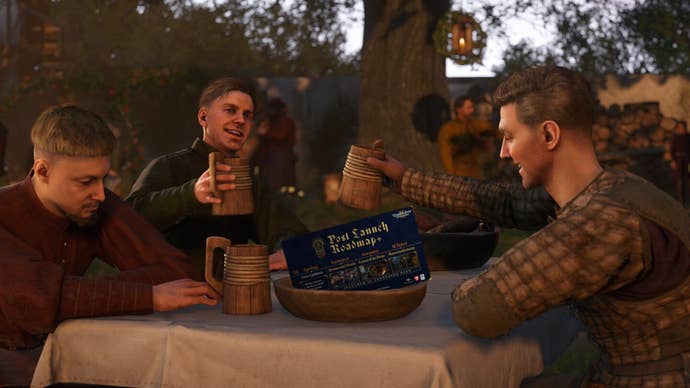 A Kingdom Come: Deliverance 2 screenshot showing three characters drinking around a table. Two are raising their tankards in a toast while the third looks glum. A small post-launch development roadmap has been Photoshopped into the bowl in front of them.
