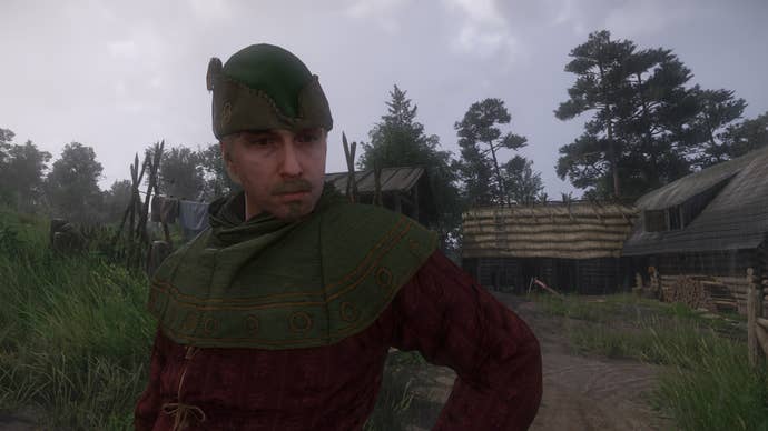 A close-up of the Gamekeeper, Vostatek, standing outside his house in the rain in Kingdom Come: Deliverance 2.