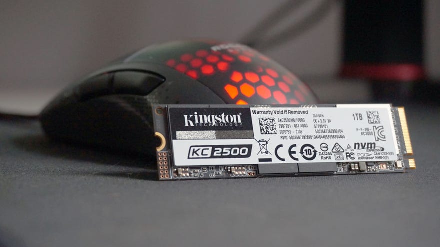 A photo of the Kingston KC2500 SSD in front of an RGB gaming mouse