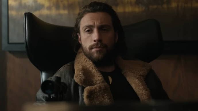 Aaron Taylor-Johnson as Kraven the Hunter in the titular film, he is sat in a chair with a smug expression on his face, an eyesight from a gun appearing at the bottom of the frame.