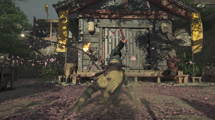 Naoe swings her kusarigama against an armored foe in Assassin’s Creed Shadows, sending layers of sakura petals flying through the air.