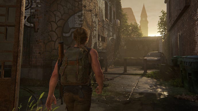 Abby marche dans une ruelle pendant que le soleil se couche derrière un mur dans The Last of Us 2 Remastered