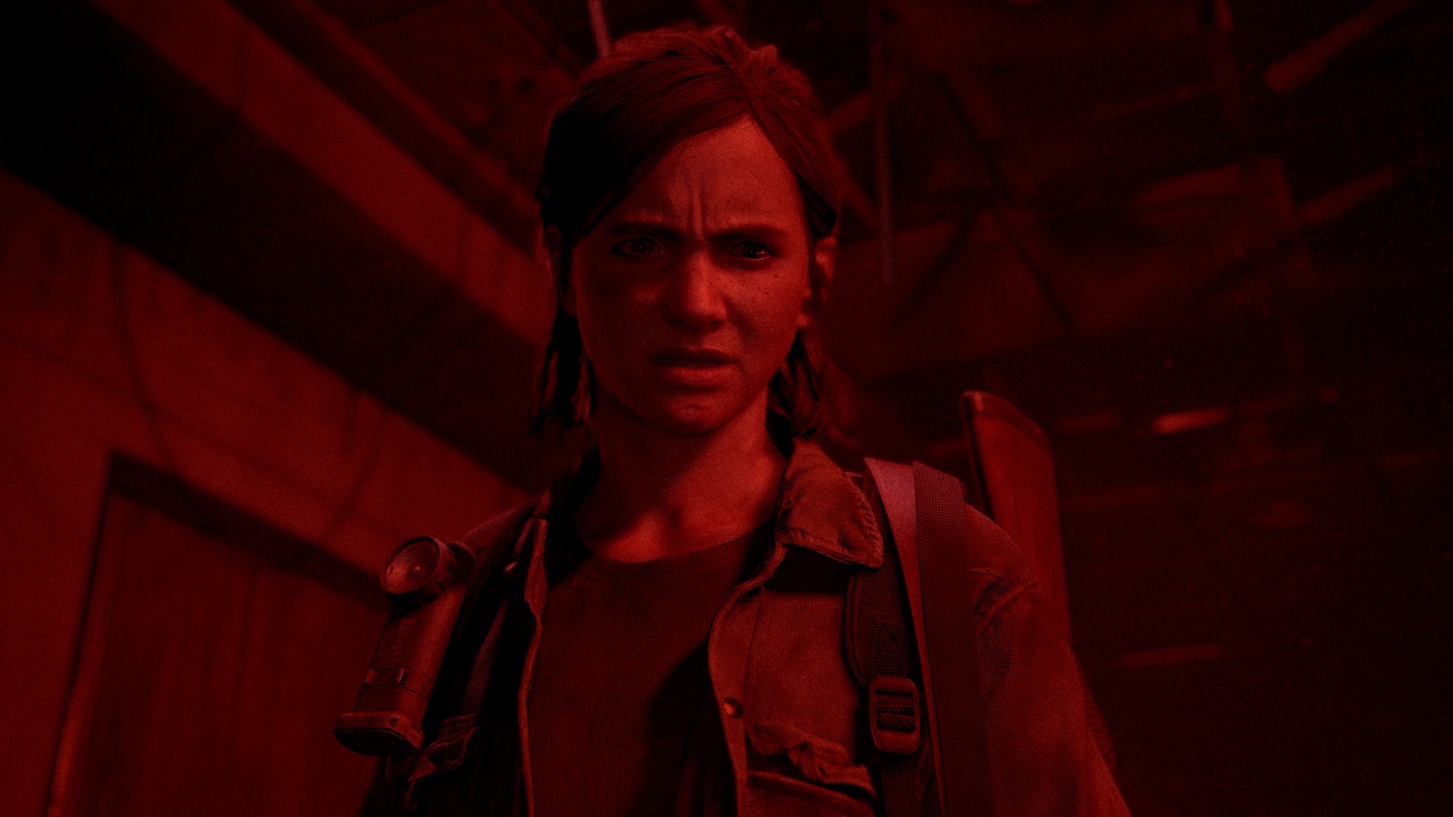 Ellie from The Last Of Us Part 2 is bathed in a sinister red light. - 1
