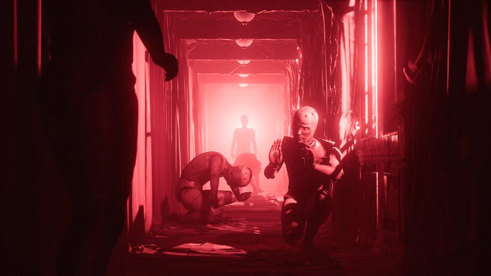 In an entirely red-lit corridor, several mannequins cower in poses of fear and submission. Two more humanoid figures can be seen standing at either end of the corridor in more confident poses, although it’s hard to say if they’re mannequin or human.