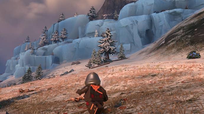 Lego Fortnite malachite - A lego man in a dark cape is walking across a frigid tundra, with ice cliffs looming in the distance.