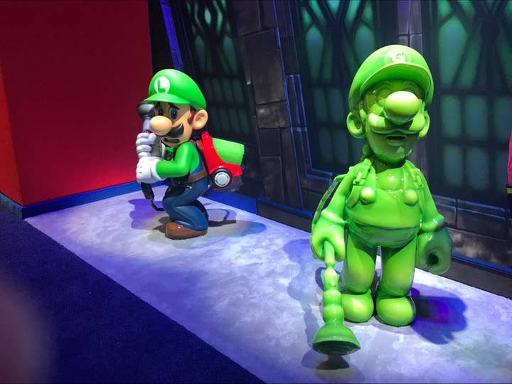 A Nintendo E3 show floor display with a statue of Luigi cowering while looking over at a statue of Gooigi, his expressionless, gelatinous clone from Luigi's Mansion 3