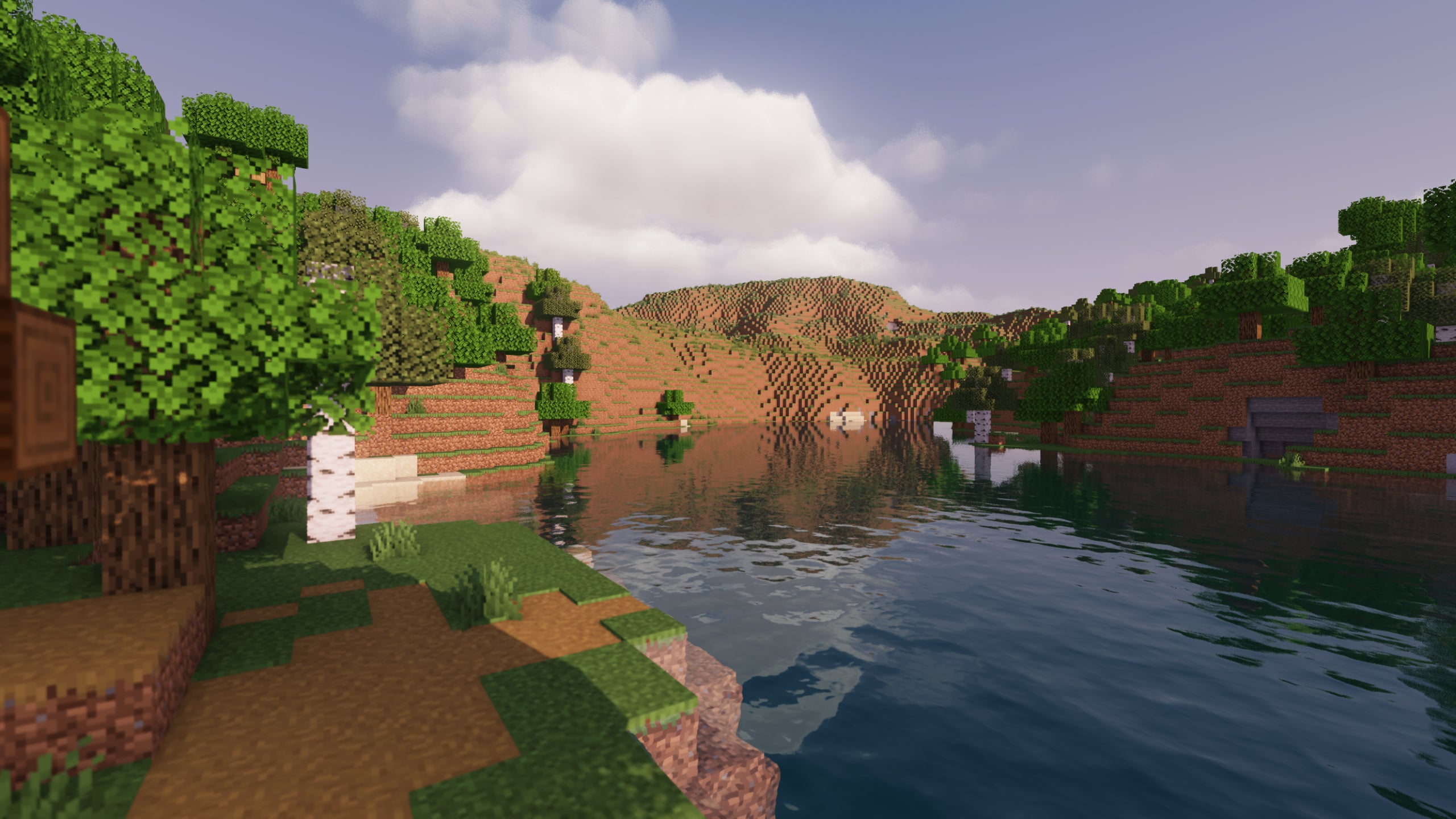 A screenshot of a river in Minecraft, with some trees on either side of the bank and a hill in the distance, taken using MakeUp shaders.