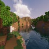 A screenshot of a river in Minecraft, with some trees on either side of the bank and a hill in the distance, taken using MakeUp shaders.