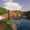 A screenshot of a river in Minecraft, with some trees on either side of the bank and a hill in the distance, taken using MakeUp shaders.