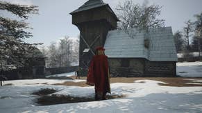 A man in a red robe and hat stands outside their manor in the snow in Manor Lords