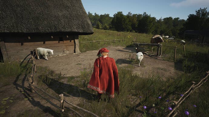 A man in a red cape and hat stands in a sheep enclosure in Manor Lords