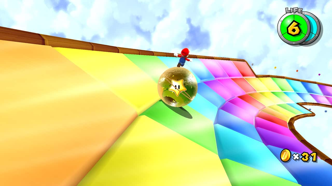 Mario rides a ball with a power star inside across a rainbow-colored pathway.