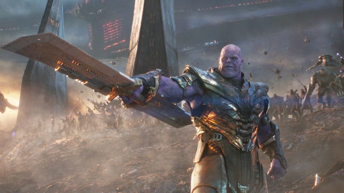 Thanos is stood wearing a suit of armour, a large double ended blade pointed away from him, his army in the background in Avengers: Endgame.