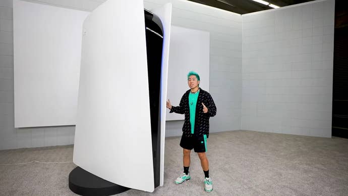 A man stands next to a 10ft tall PlayStation 5