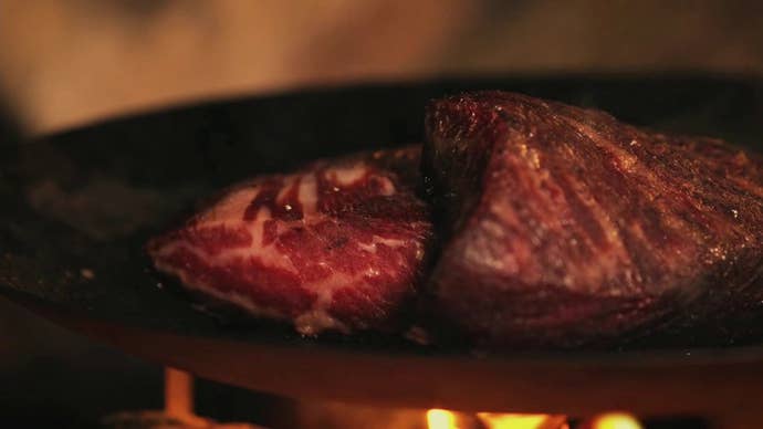 Meat sizzling on a pan over a campfire in Dragon’s Dogma 2