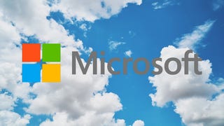 Microsoft's logo over a blue sky filled with white fluffy clouds.