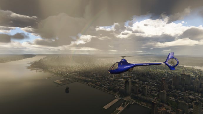 A blue helicopter flies over a rainy city.