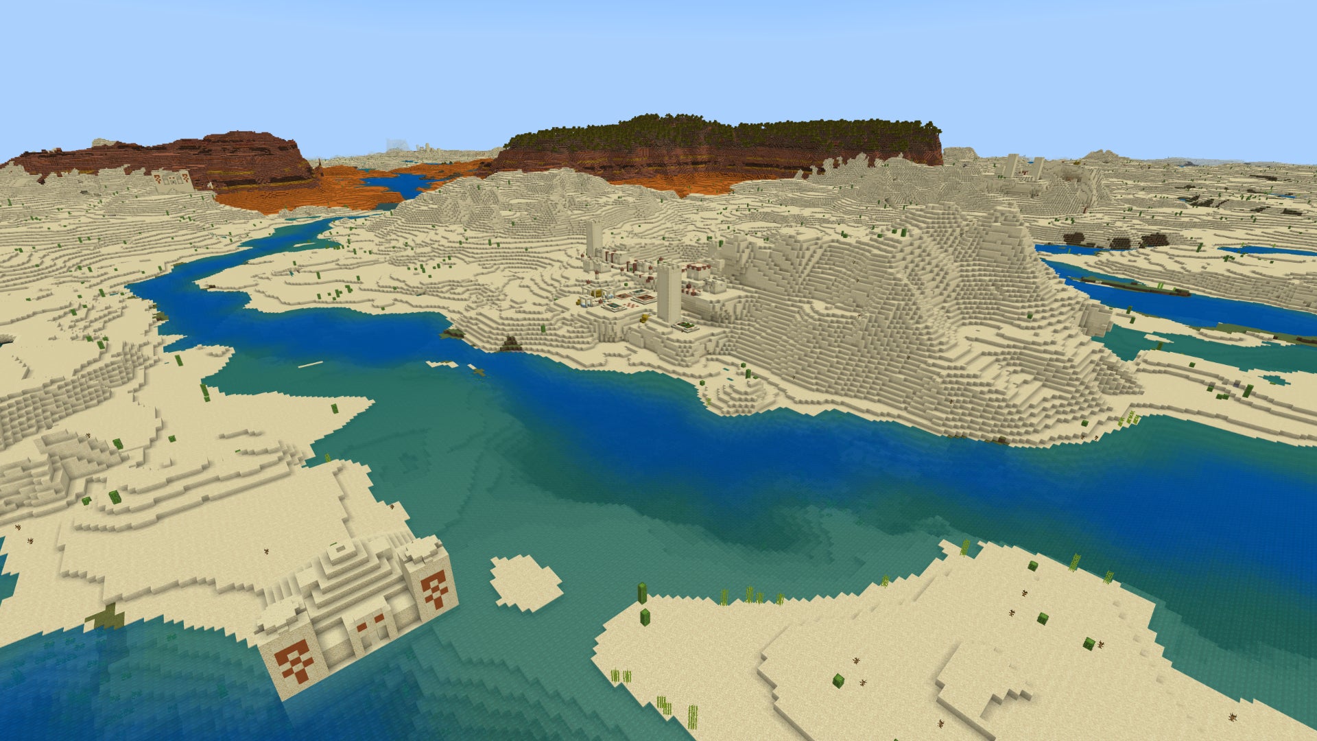 Screenshot of a Minecraft Bedrock landscape with desert and river in the foreground and badlands in the distance. - 12