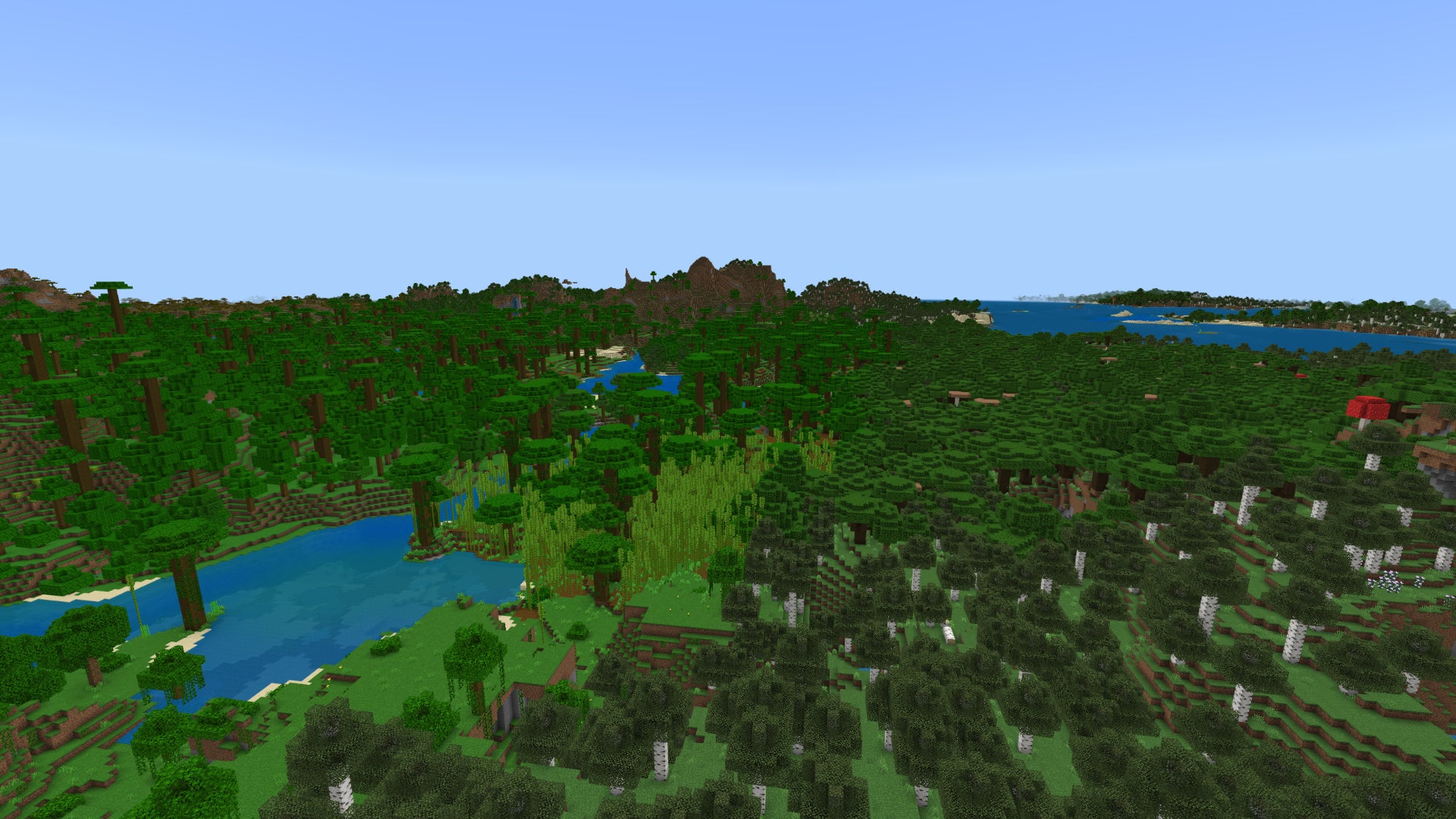 Screenshot of a forest-covered Minecraft Bedrock landscape, with Jungle on the left, birch forest on the right, and mountains in the background. - 17